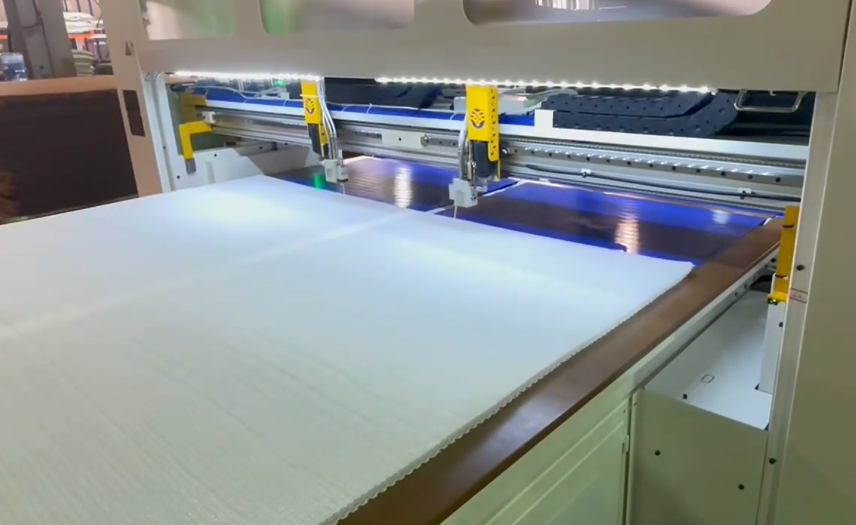 Automatic hot melt adhesive spraying on mattress panel